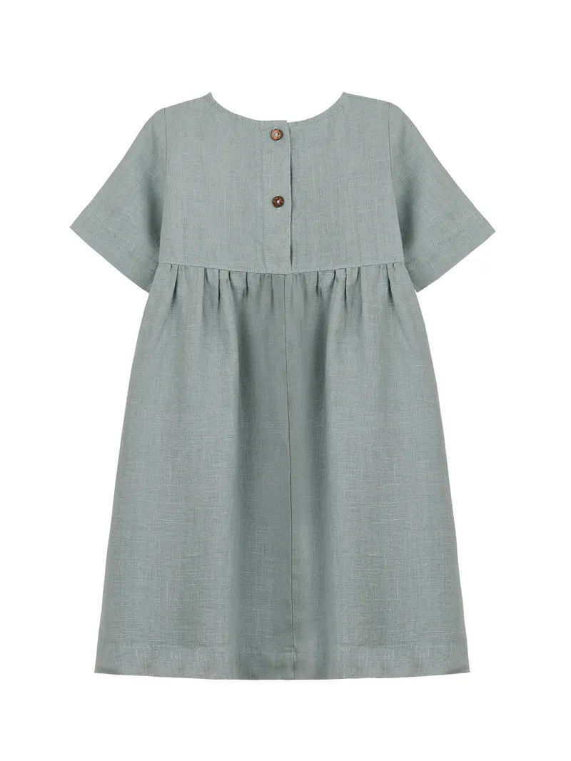 Nature's Baby льняное платье в мятном оттенке. Деревянные пуговицы как акцент. Текстура льна передана идеально — видно плетение. Hero для детского сегмента.