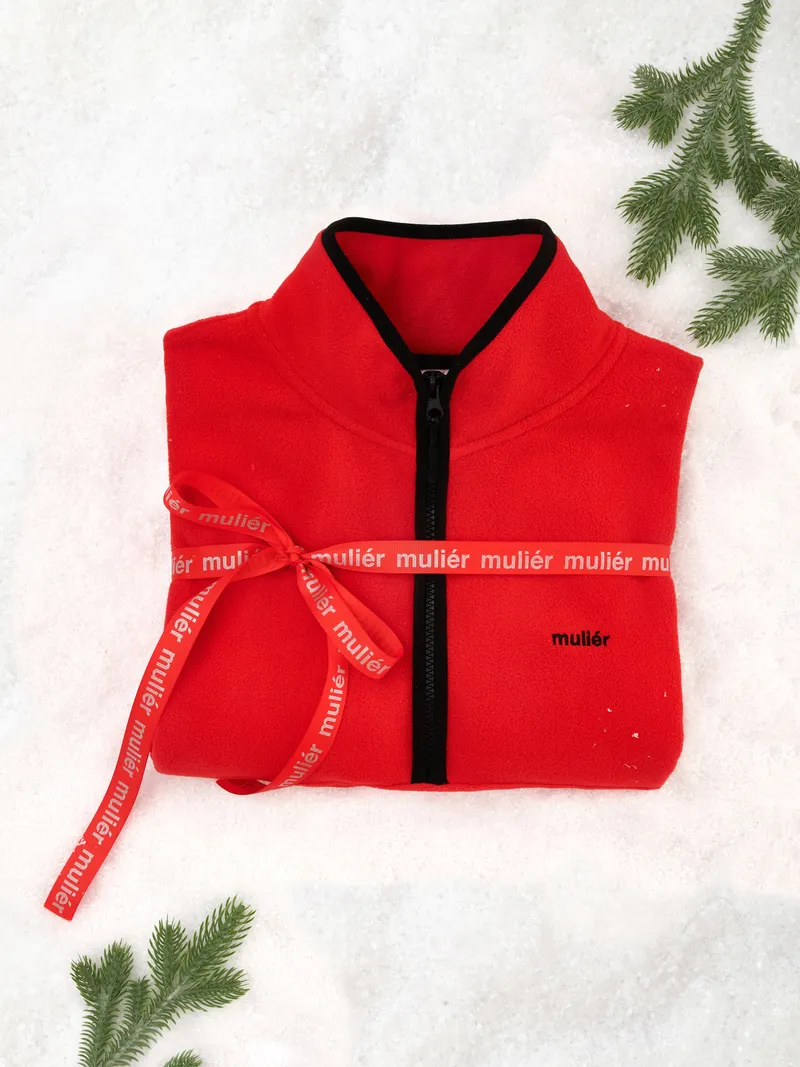 Праздничный flatlay - красная флисовая куртка с брендированной лентой и еловыми ветками. Сезонный контент.